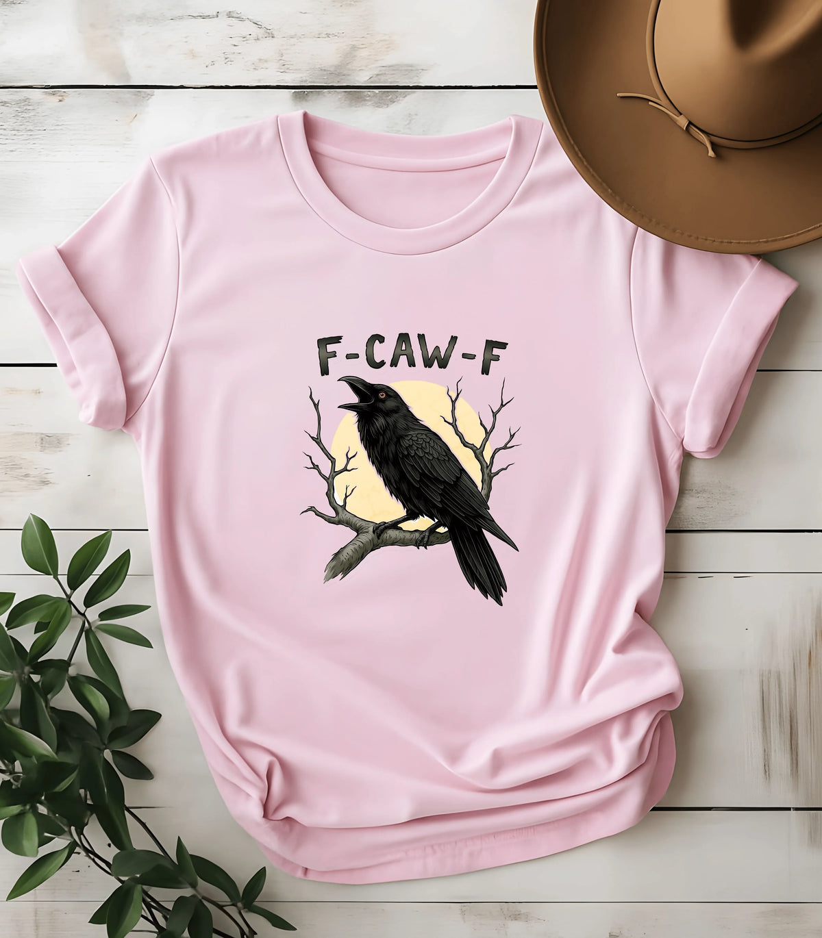 Funny F-CAW-F crow graphic t-shirt on pink tee with moon and branches