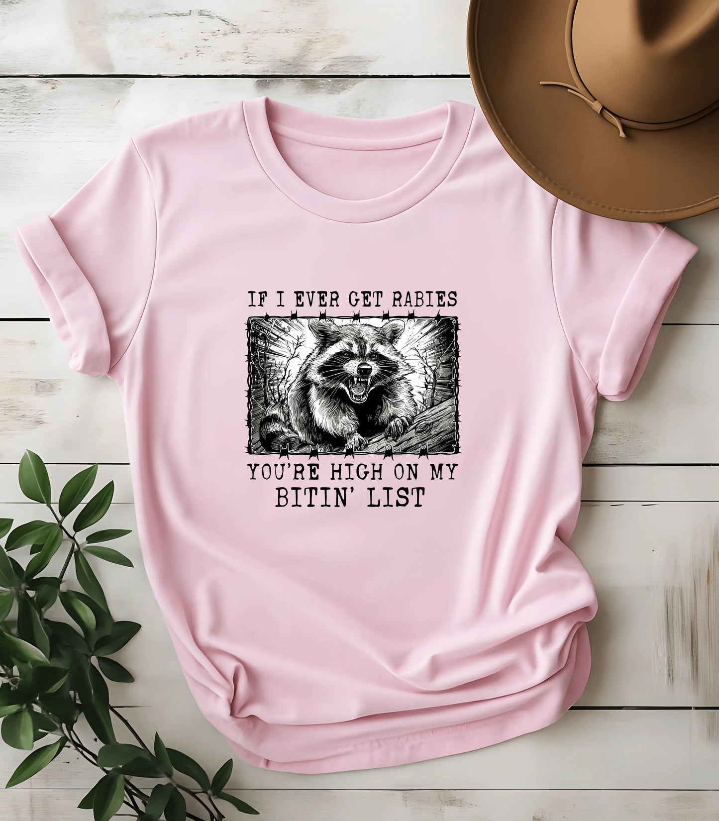Funny raccoon graphic tee with bold text on pink shirt