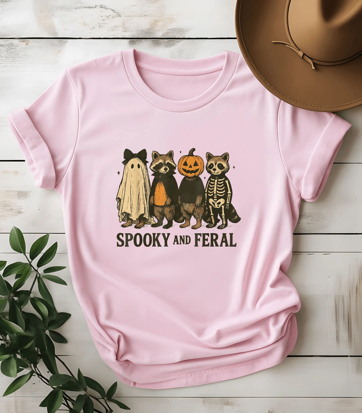 Spooky and Feral Halloween raccoon graphic tee on pink shirt