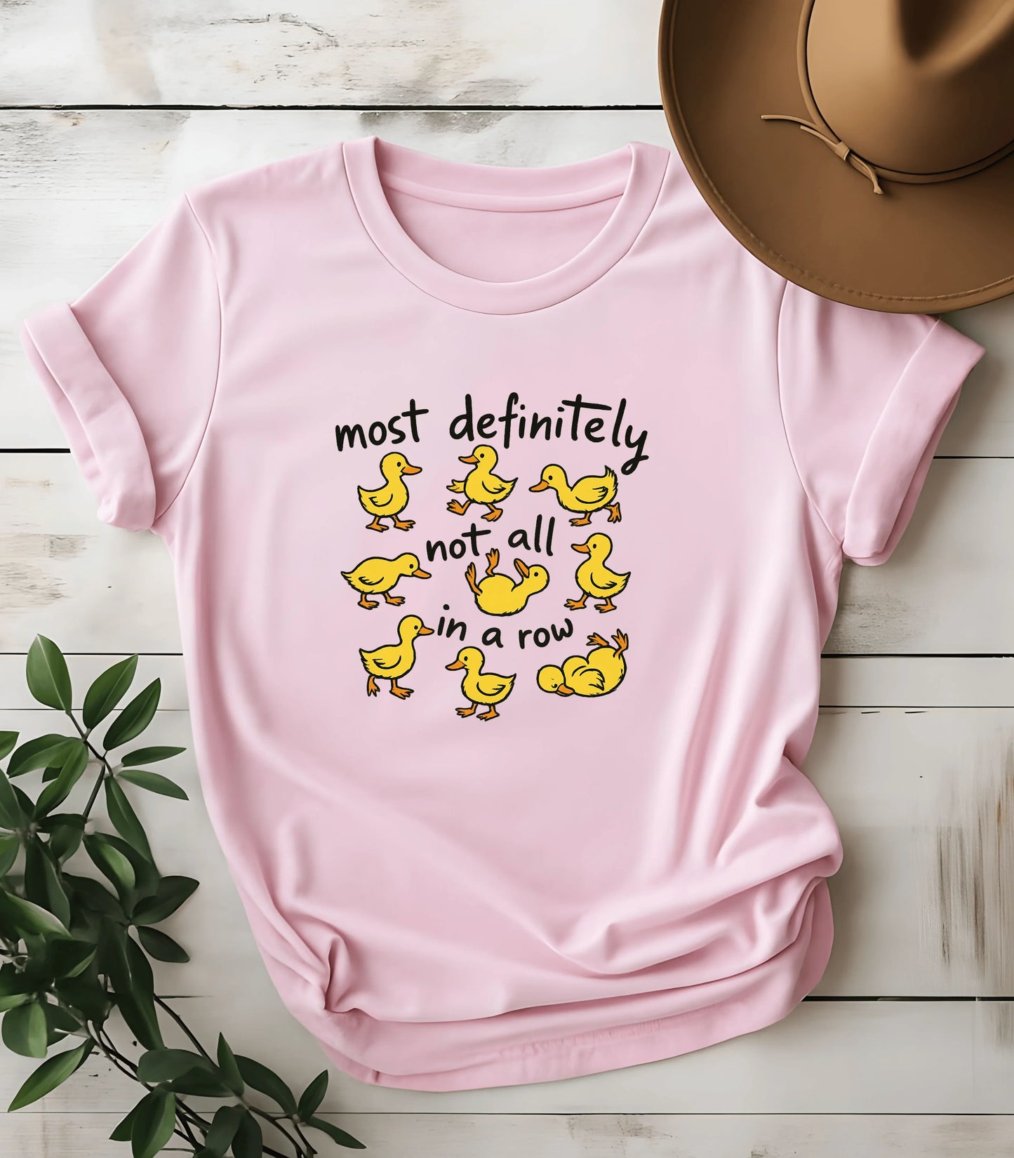 Funny duck graphic tee with 'most definitely not all in a row' text on pink shirt