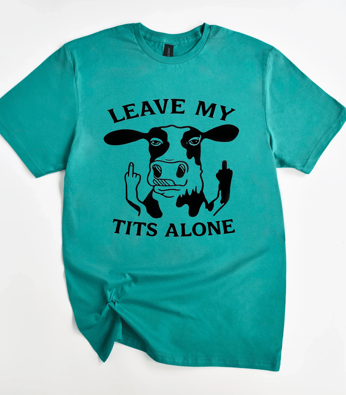 Funny cow graphic t-shirt with 'Leave My Tits Alone' text on teal tee