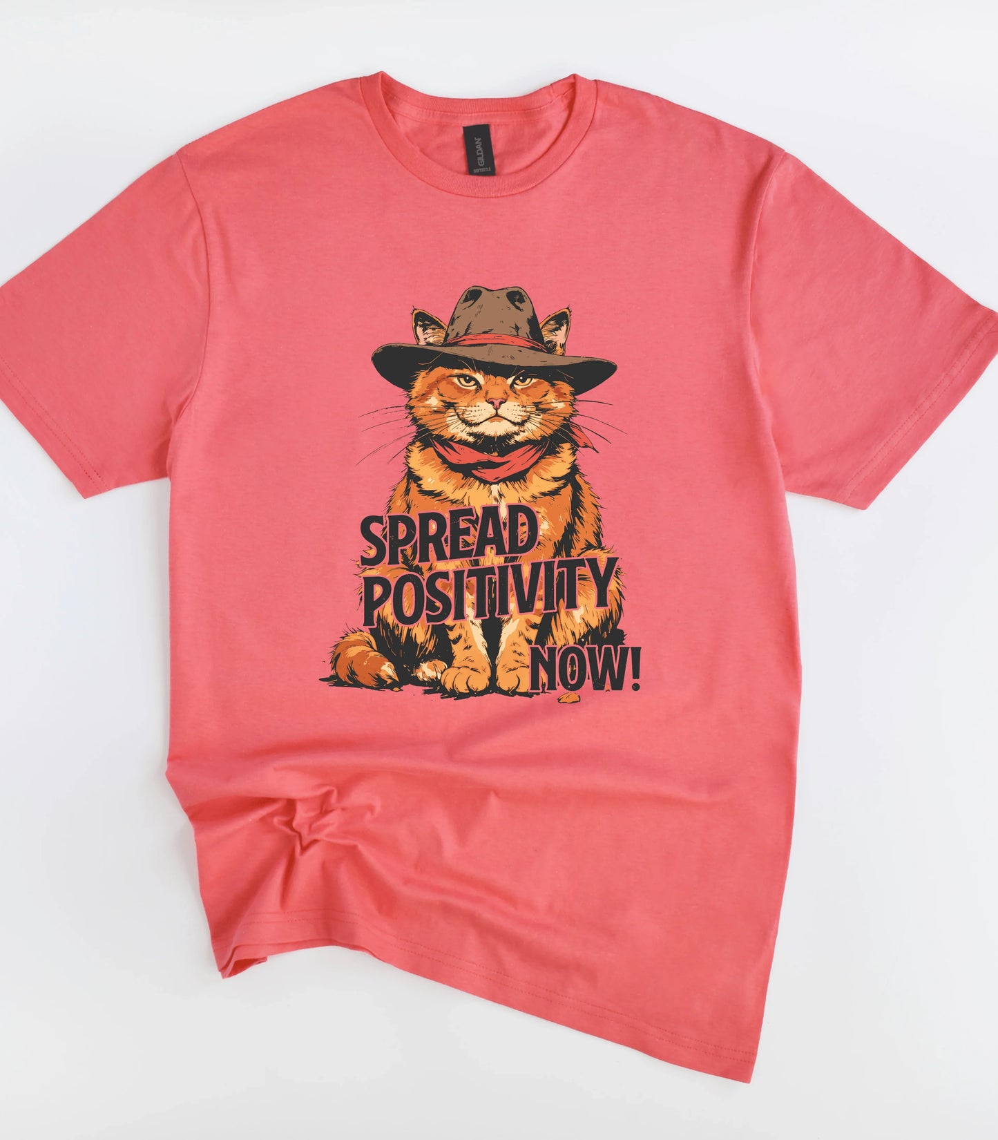 Funny cat graphic tee with 'Spread Positivity Now!' text on coral shirt
