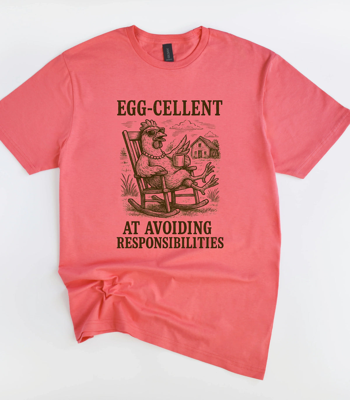 Funny chicken graphic tee with 'Egg-cellent at avoiding responsibilities' text on coral shirt