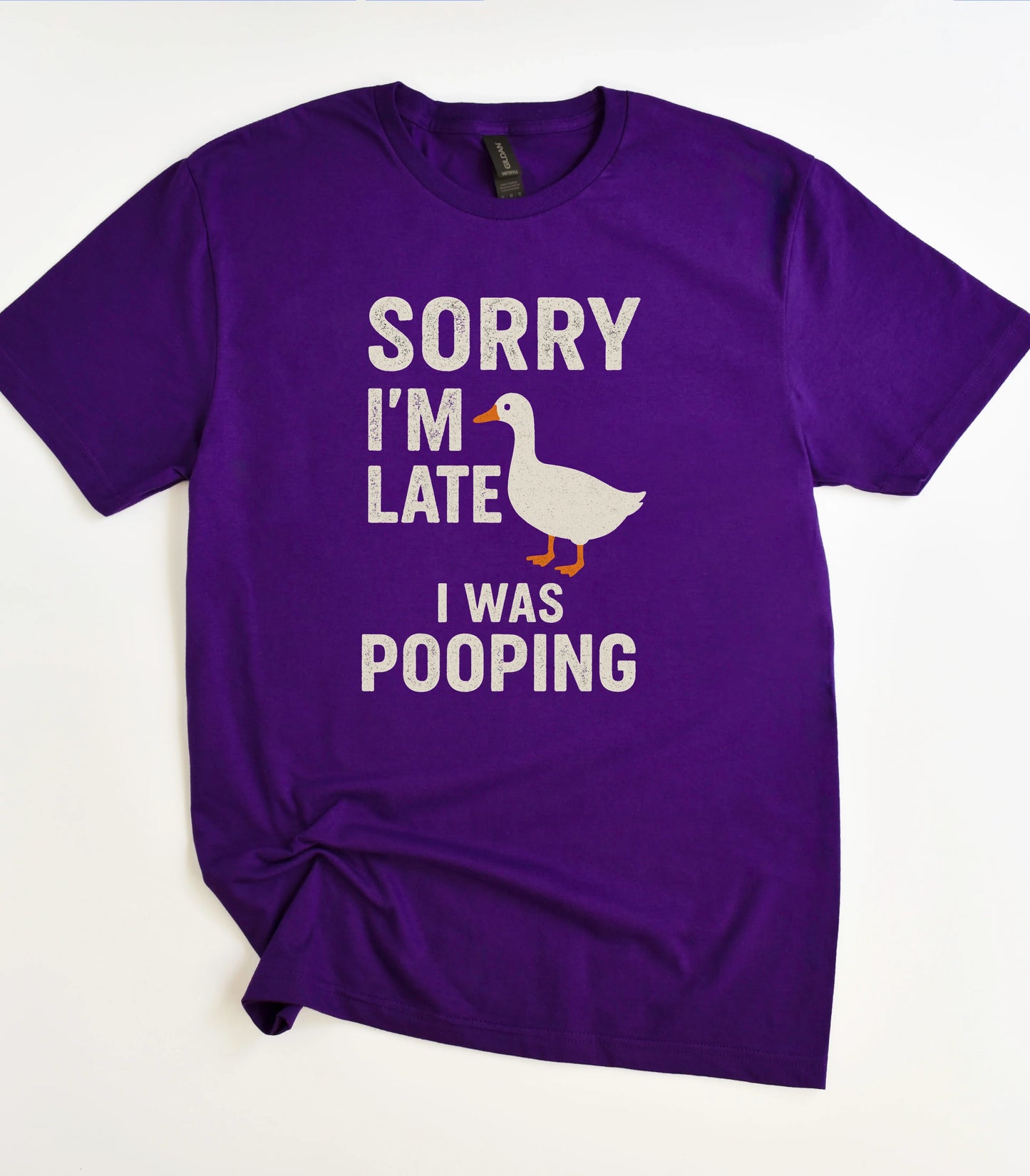 Funny duck graphic tee with 'Sorry I'm Late I Was Pooping' text on purple shirt