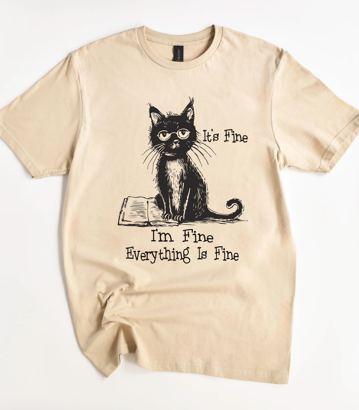 Funny cat graphic tee with 'It's Fine I'm Fine Everything Is Fine' text on beige shirt