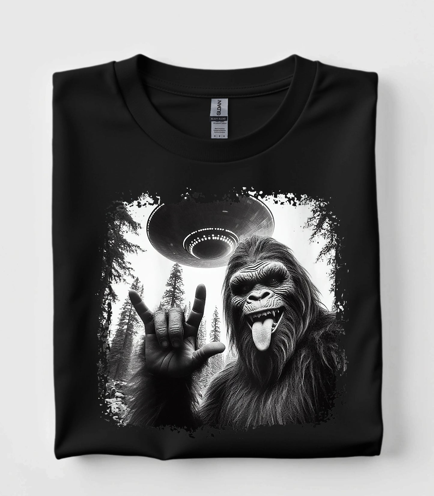 Funny Bigfoot graphic tee with UFO and rock on hand gesture on black t-shirt