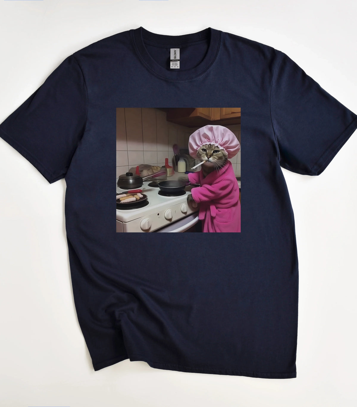 Funny cat in pink robe and shower cap cooking on stove graphic tee